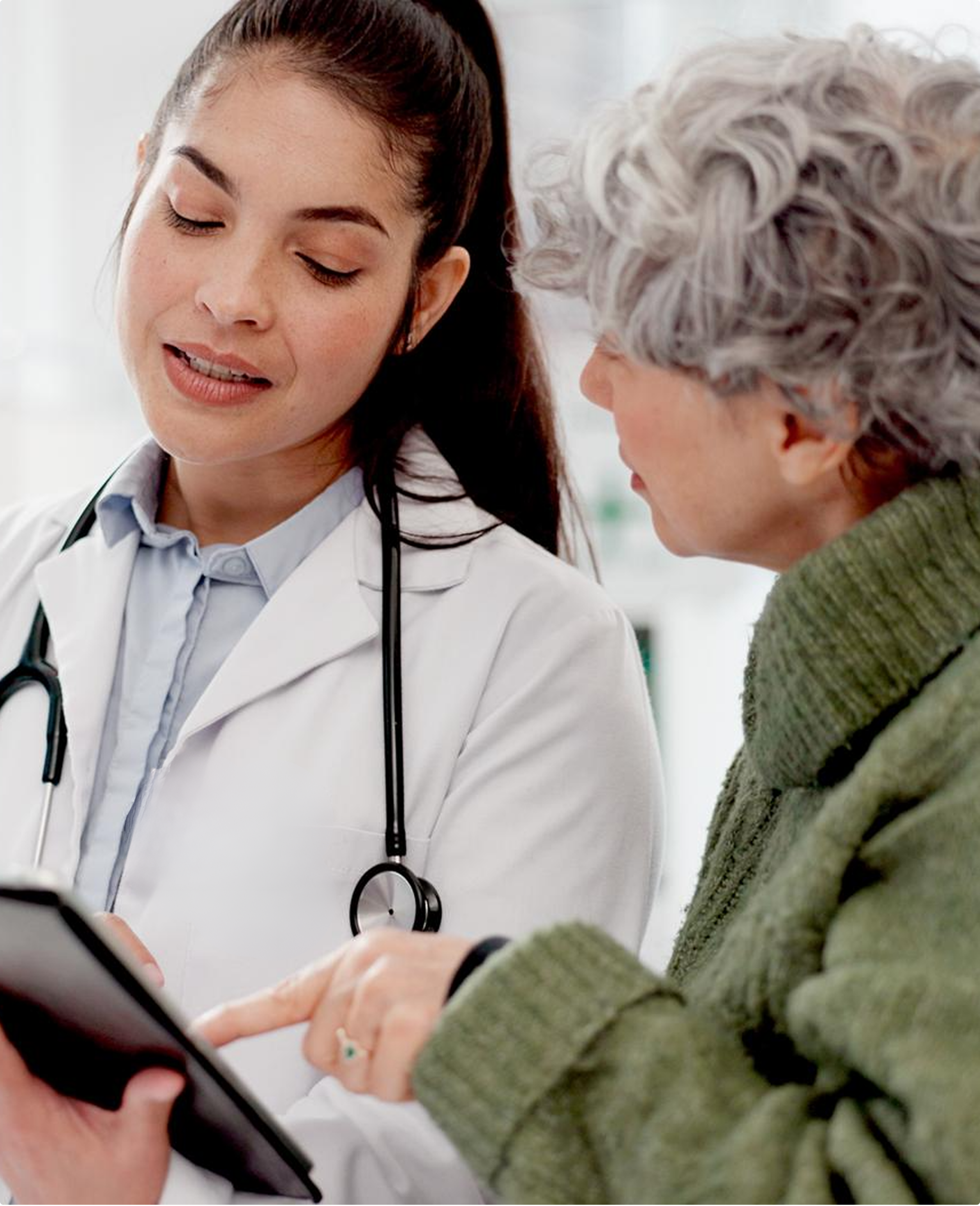 A clinician reviewing a tablet with an older adult patient