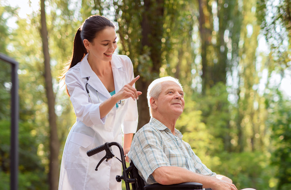 A caregiver walking outdoors with an older adult